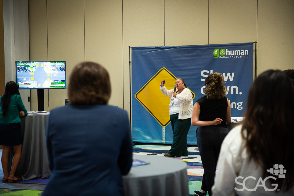 People at a conference with a speaker and blue backdrop.